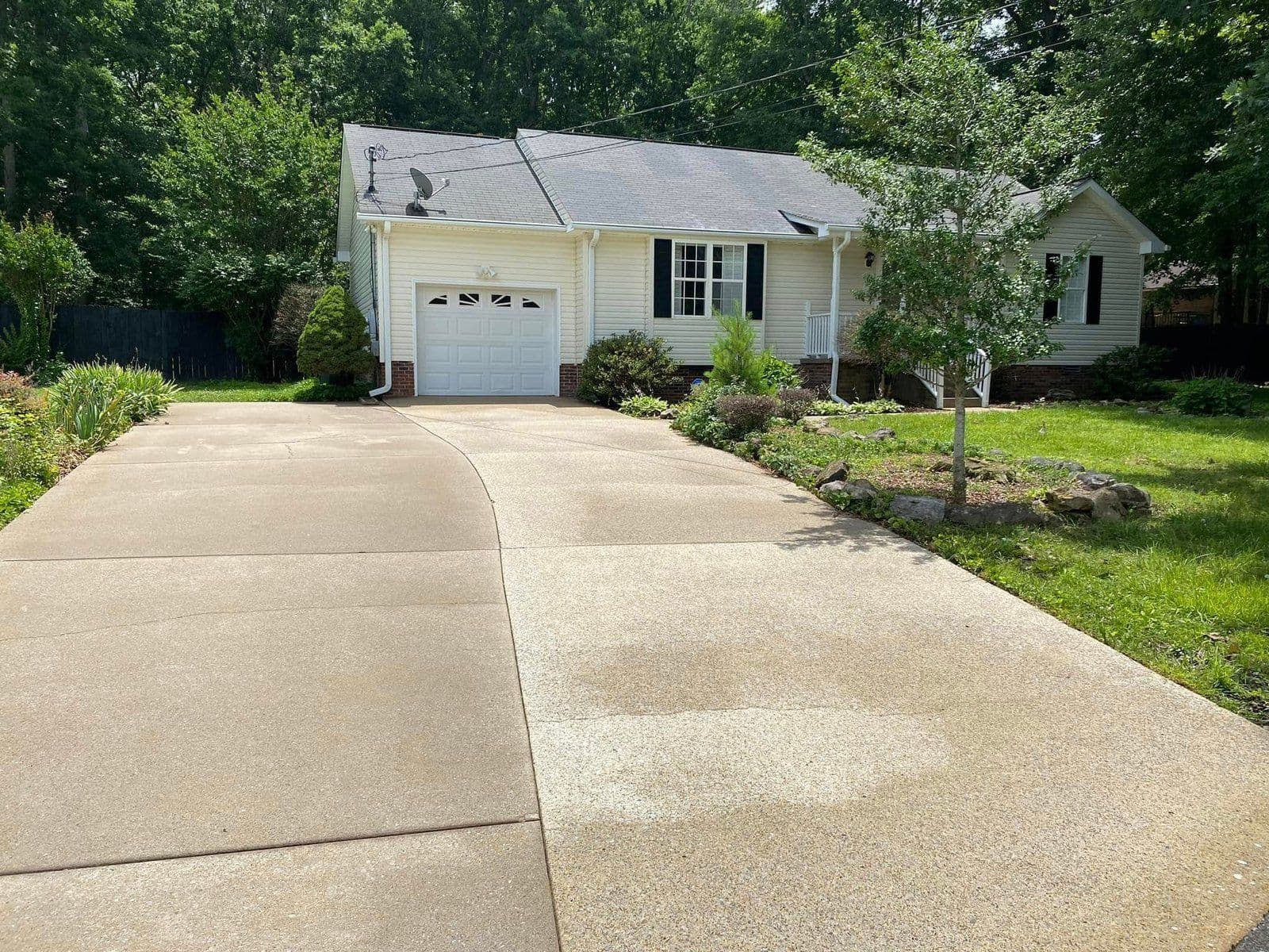 Single-story house with a front lawn, driveway, and trees in a residential neighborhood.